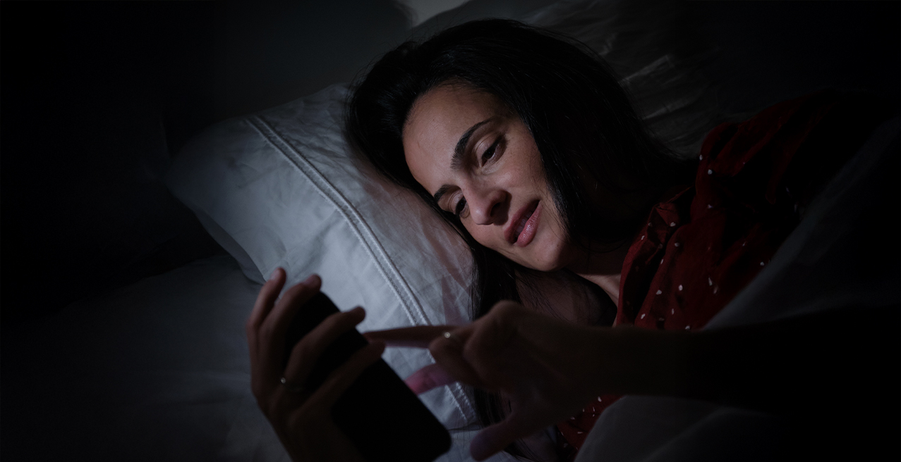 digital detox ragazza a letto con cellulare acceso